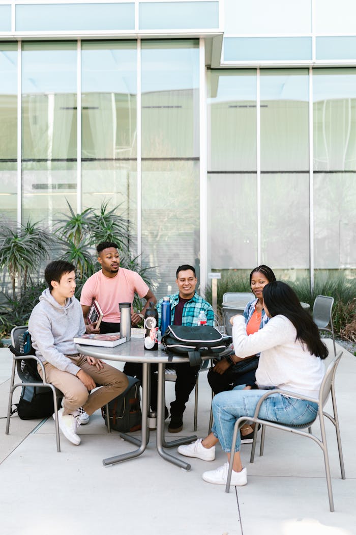 A diverse group of college students studying together outside a modern building.