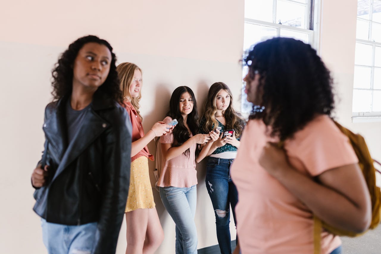 Group of diverse teenagers hanging out in a school hallway, chatting and enjoying each other's company.